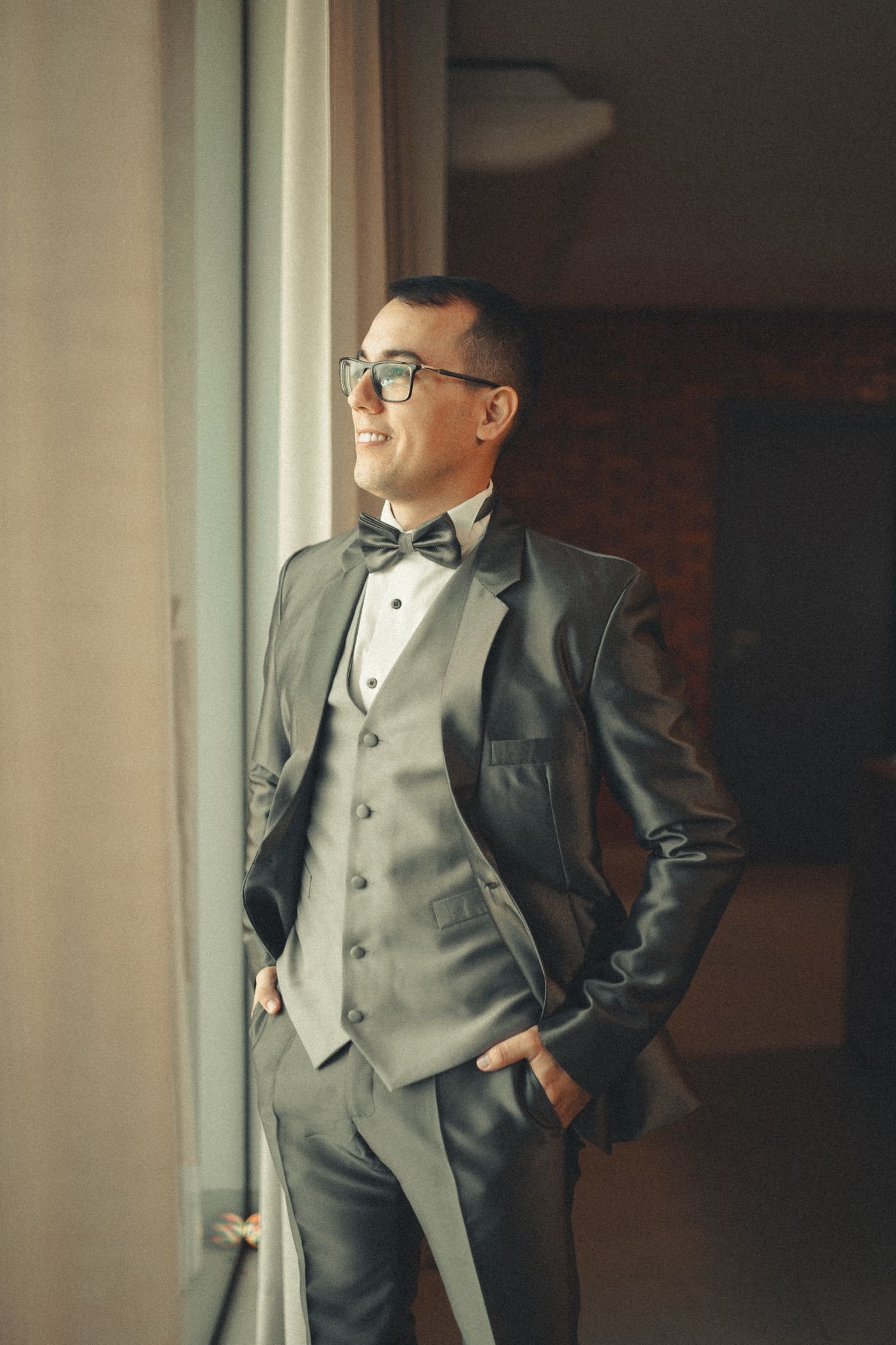Representative photo of a man wearing a fitted grey three-piece suit with a bow tie