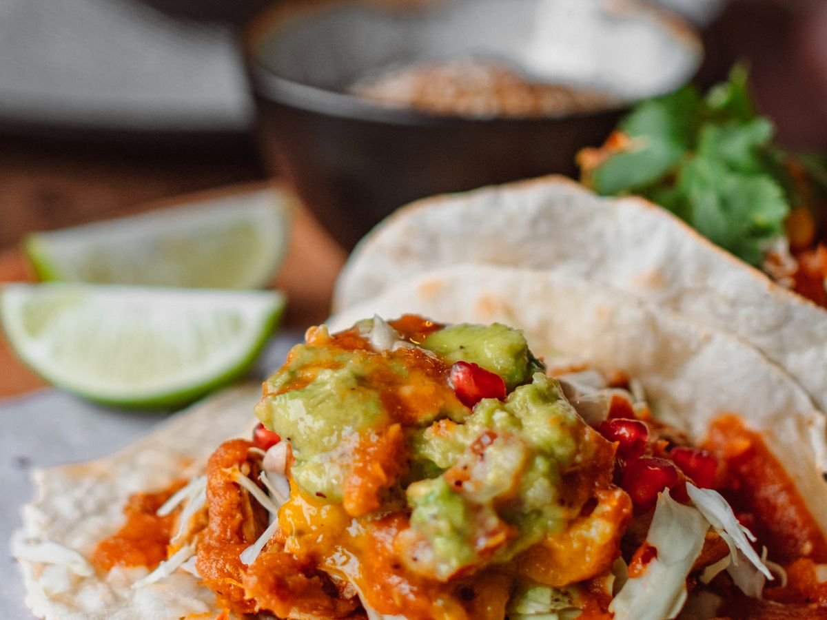 Primer plano de tacos latinos de calle con ingredientes frescos, representativo de la comida de El Buen Sabor