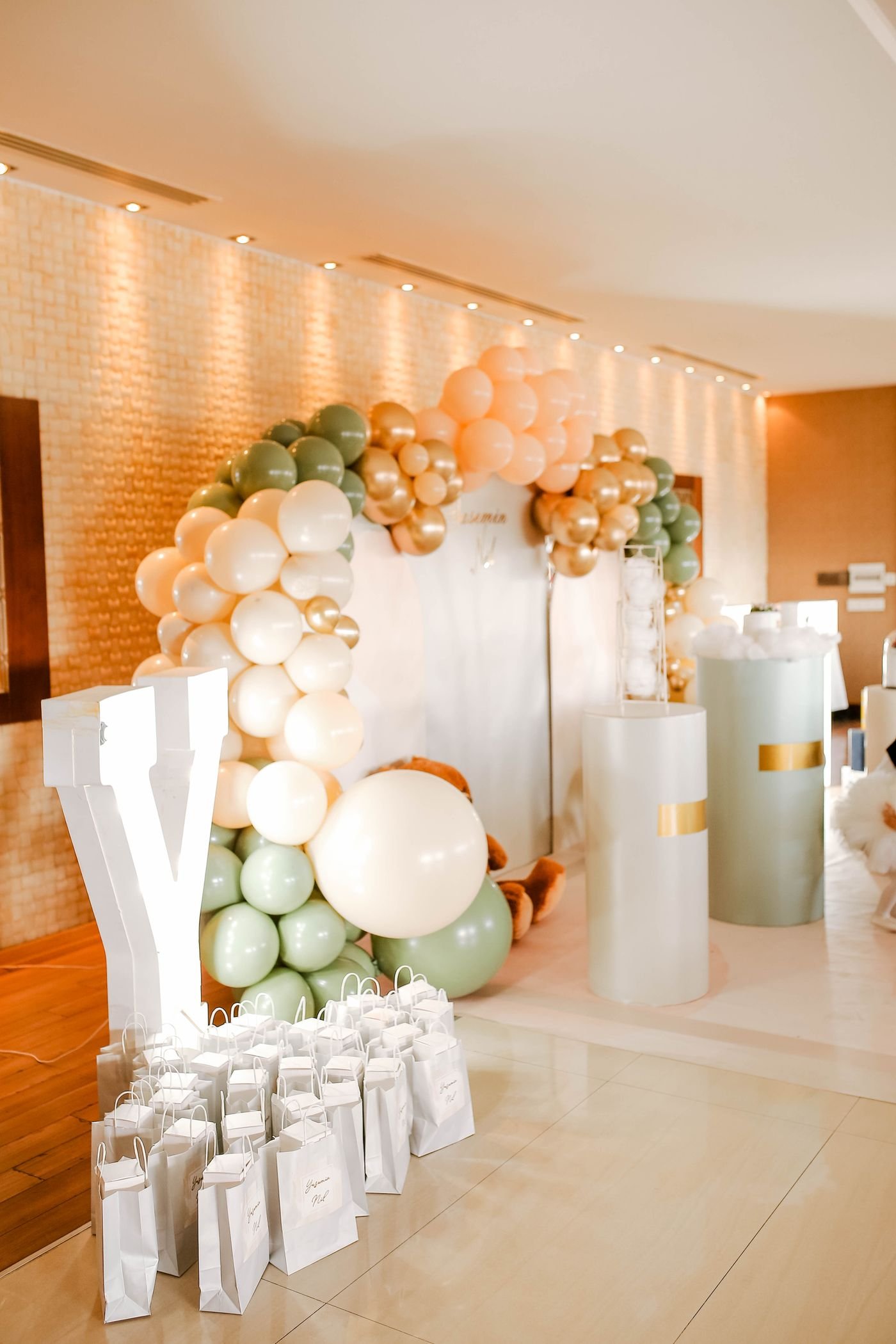 Representative photo of a balloon arch and event backdrop in sage and gold.