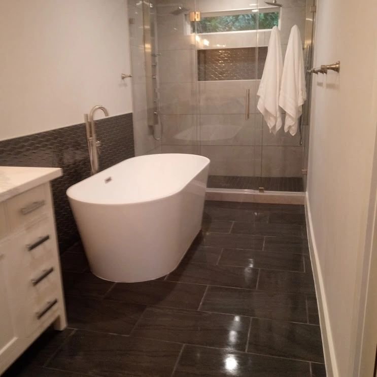 Remodeled master bathroom with freestanding tub and glass shower by Olivo Remodeling