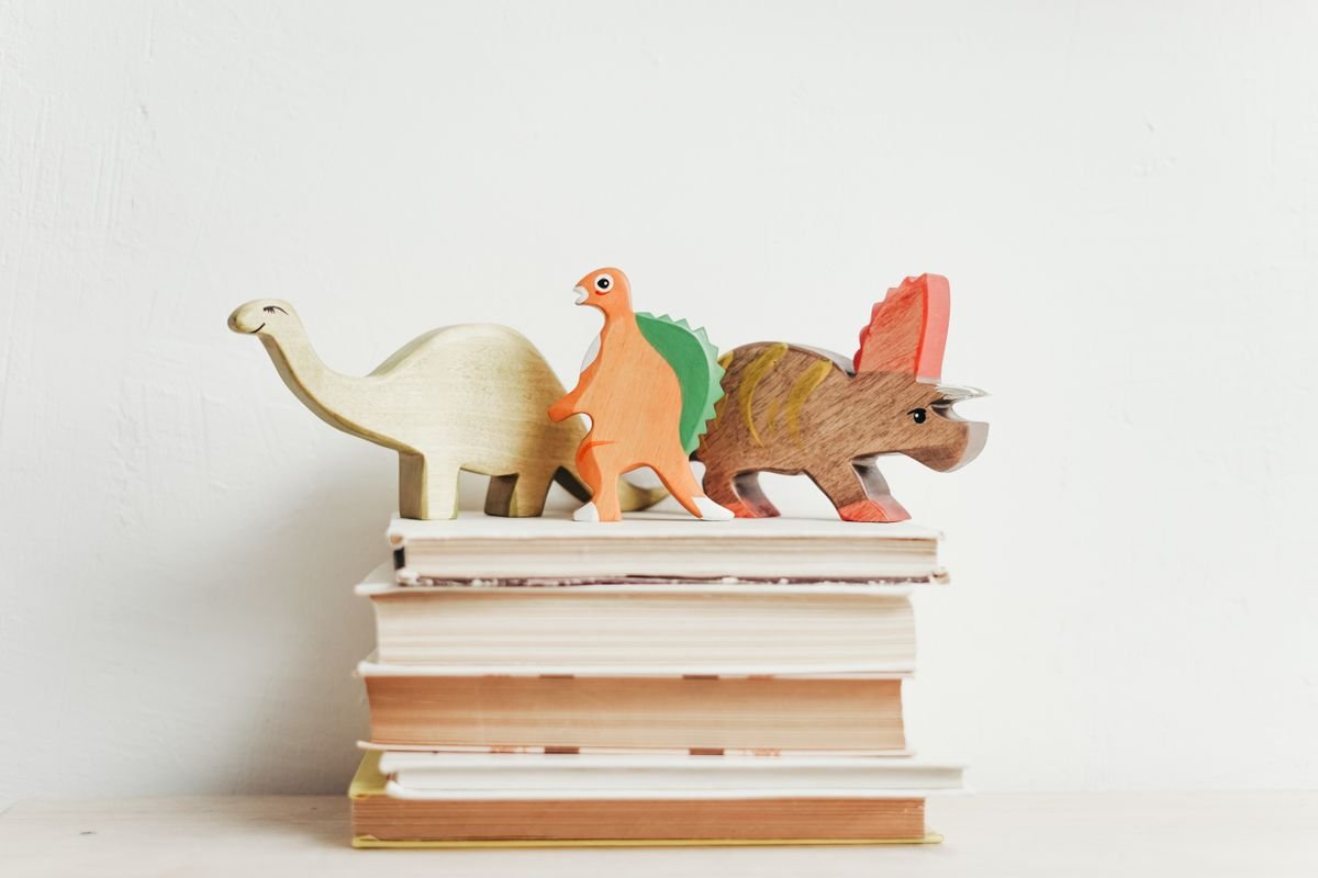 Representative photo of wooden toy figures resting on a stack of children's books