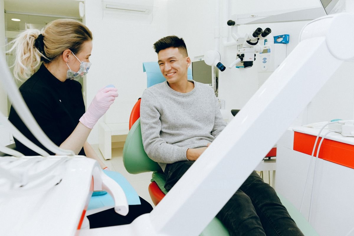 Representative photo of a relaxed, smiling patient talking with a dental professional in the treatment chair
