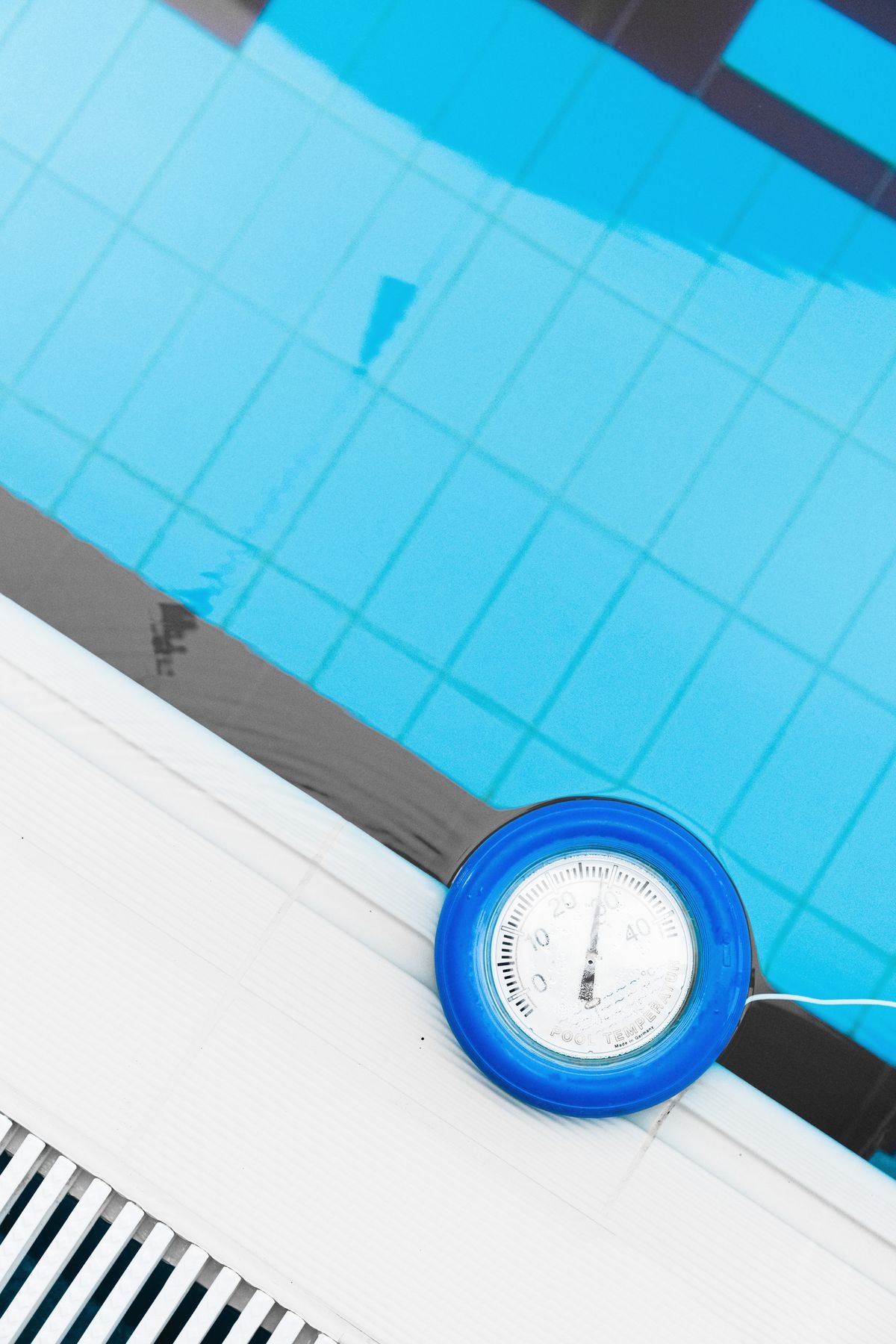 Representative photo of a floating pool thermometer on clear blue pool water